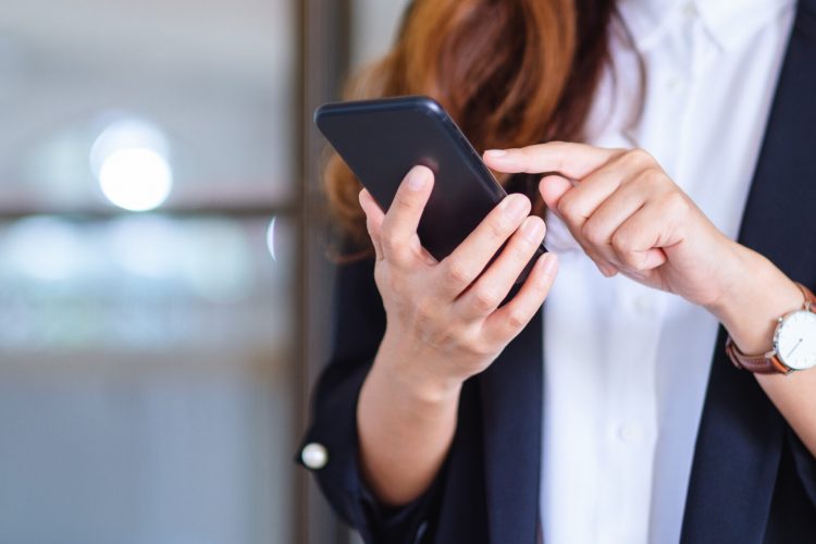 Closeup image of a businesswoman holding and using mobile phone Closeup image of a businesswoman holding and using mobile phone